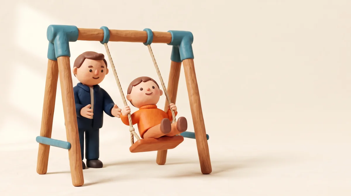 ילד מחימר מתנדנד בנדנדה, ומבוגר שעומד לידו דוחף אותו